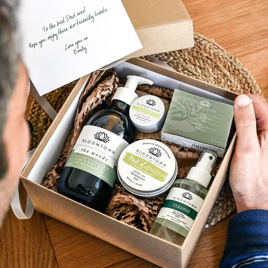 Gift box with skincare products and a card on a wooden surface